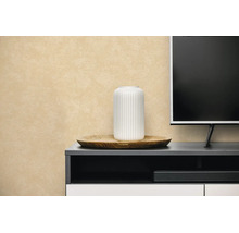 Vliesbehang met structuur in beige achter een dressoir met decoratie en televisie.