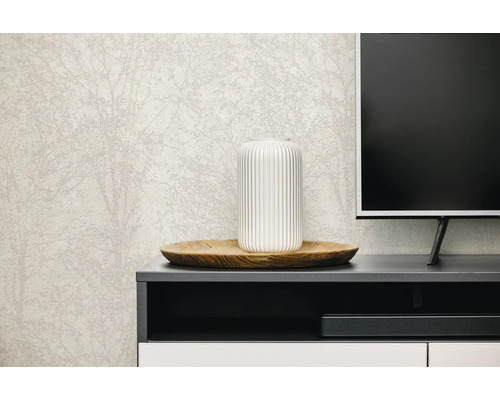 Vliesbehang met subtiel boom- en takkenpatroon op een muur achter een dressoir met decoratie en televisie.