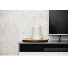 Gestructureerd behang met steenlook in een moderne woonkamer achter een dressoir met decoratie.