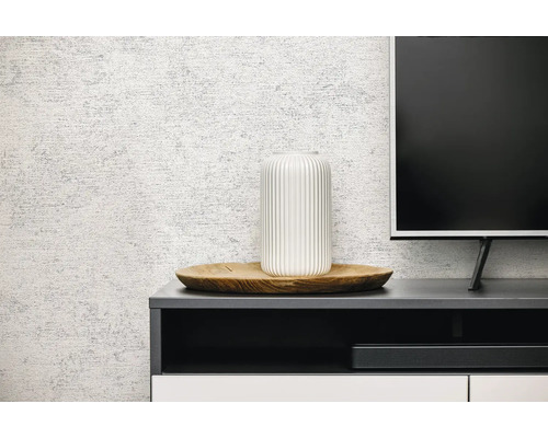 Gestructureerd behang met steenlook in een moderne woonkamer achter een dressoir met decoratie.