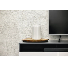 Gestructureerd behang met linnenlook achter een donker dressoir met een witte vaas op een houten dienblad en een televisie.