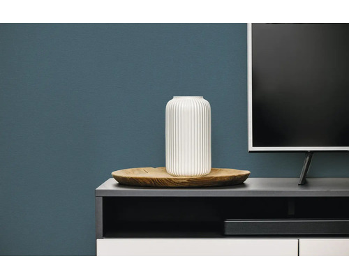 Woonkamer met televisiemeubel, televisie, houten schaal en een vaas met verticale ribbelstructuur.