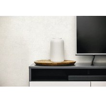 Woonkamer met wand met textuur, tv-meubel, houten decoratiebord en geribbelde vaas.