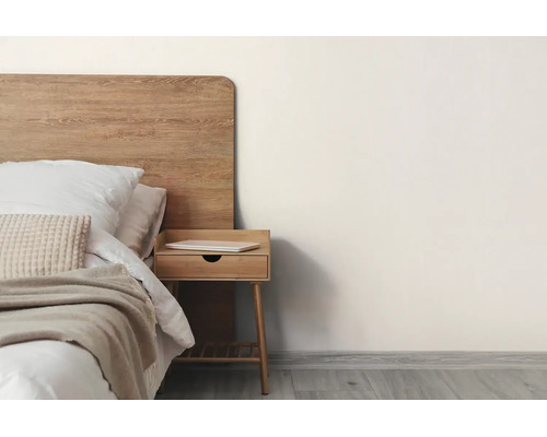 Minimalistische slaapkamer met een houten hoofdbord, bed met wit beddengoed en beige sprei, en een houten nachtkastje.