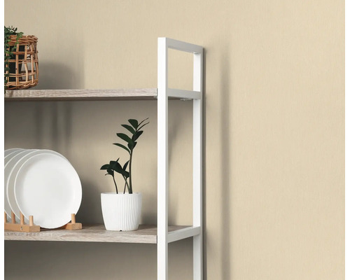 Beige vliesbehang met subtiele structuur achter een wit rek met decoratie.