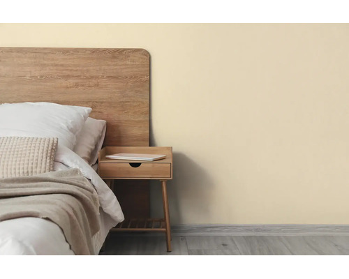 Licht ingerichte slaapkamer met beige muur, houten bed en bijpassend nachtkastje op grijze vloer.