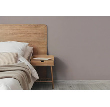 Moderne slaapkamer met houten hoofdbord, bijpassend nachtkastje en een mauve muur.