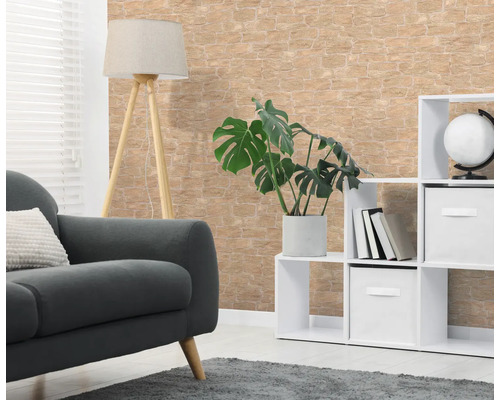 Vliesbehang in steenlook in de woonkamer met bank, vloerlamp, witte kast en kamerplant.