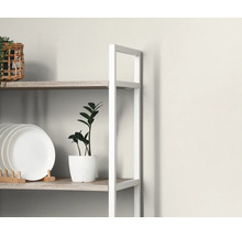 Open stellingkast met wit metalen frame en houten planken, ingericht met borden, een plant in pot en een mand.