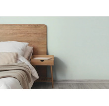 Moderne slaapkamer met houten hoofdbord, houten nachtkastje en een lichte muurverf.