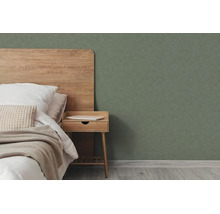 Moderne slaapkamer met houten hoofdbord, houten nachtkastje en donkergroen structuurbehang.