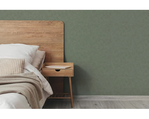 Moderne slaapkamer met houten hoofdbord, houten nachtkastje en donkergroen structuurbehang.