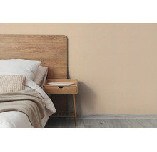 Moderne slaapkamer met beige muur, houten hoofdbord, nachtkastje en licht beddengoed.