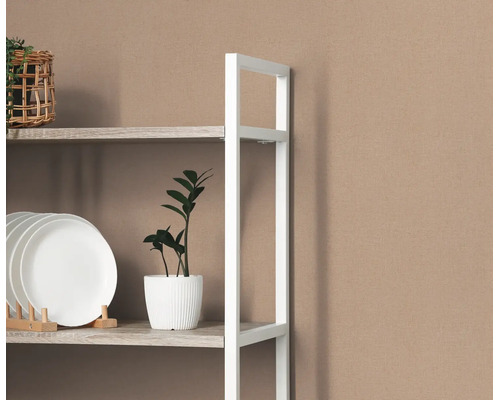 Wit metalen rek met houten planken voor een gestructureerd behang, gedecoreerd met borden en een kamerplant.