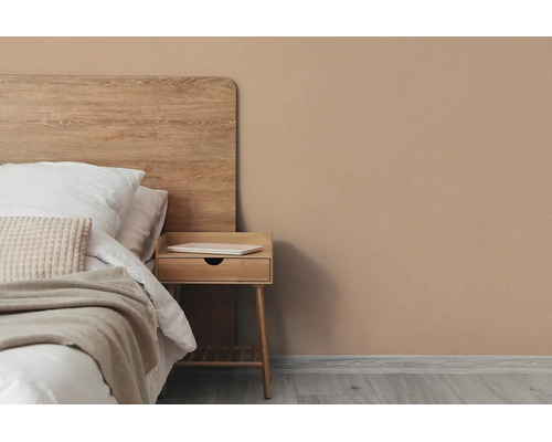 Helder ingerichte slaapkamer met houten bed, houten nachtkastje en muurverf in aardetint.