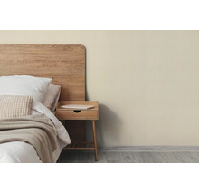 Slaapkamer met beige geverfde muur, houten bed, nachtkastje en licht textiel in een natuurlijk ontwerp.