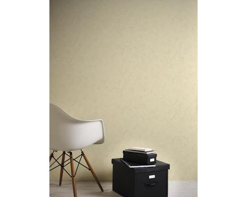 Wand met behang met textuur in een lichte, modern ingerichte kamer met een witte stoel en zwarte opbergdozen.