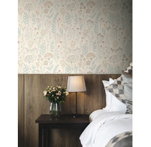 Vliesbehang met floraal patroon in een slaapkamer boven een houten lambrisering, naast een nachtkastje met lamp en bloemen.