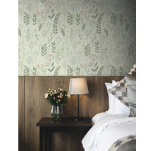 Vliesbehang met botanisch patroon van bladeren en bloemen in een slaapkamer met houten wandpanelen, nachtkastje, lamp en rozen.