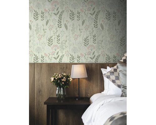 Vliesbehang met botanisch patroon van bladeren en bloemen in een slaapkamer met houten wandpanelen, nachtkastje, lamp en rozen.