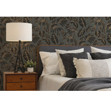 Moderne slaapkamer met tropisch behang, houten nachtkastje, een driepoot tafellamp en een bed met kussens en gebreide deken.