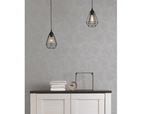 Vliesbehang met grafisch cirkelpatroon achter een dressoir met twee hanglampen in industrieel design.