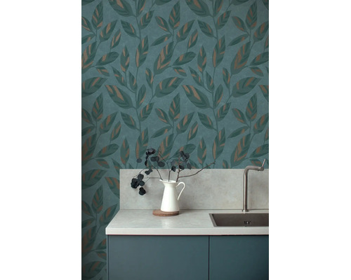 Vliesbehang met bladmotief en metallic accenten in een moderne keuken met gootsteen en aanrechtblad in steenlook.