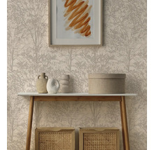 Vliesbehang met fijn boompatroon achter een lichte consoletafel met decoratieve vazen en gevlochten opbergmanden in een opgeruimde woonkamer.