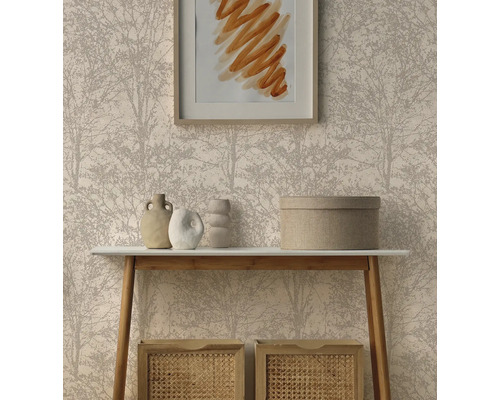 Vliesbehang met fijn boompatroon achter een lichte consoletafel met decoratieve vazen en gevlochten opbergmanden in een opgeruimde woonkamer.