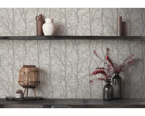 Vliesbehang met boom- en takkenpatroon achter een donkere houten plank met vazen, kaarsen en een decoratieve houten lantaarn.