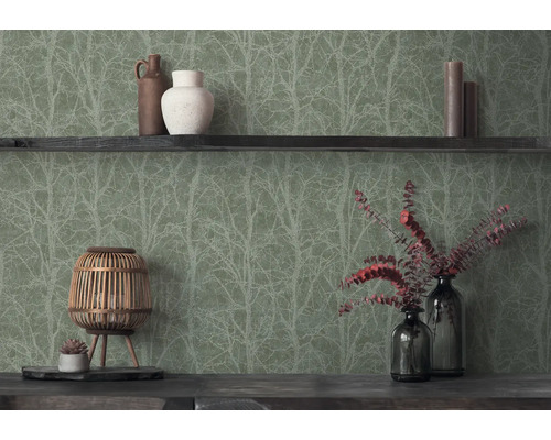 Vliesbehang met bosmotief en takkenpatroon in een interieur met houten elementen, vazen en decoratieve natuurlijke materialen.
