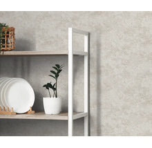 Gestructureerd vliesbehang met steenlook achter een wit rek met servies en een plant in een lichte kamer.