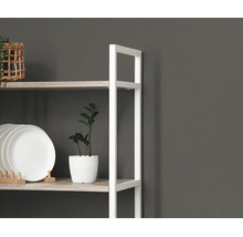 Modern rek met wit metalen frame en planken in houtlook, gedecoreerd met witte borden en een kamerplant.