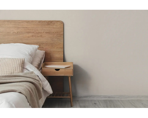 Lichte slaapkamer met houten hoofdbord, bijpassend houten nachtkastje en getextureerd beddengoed.