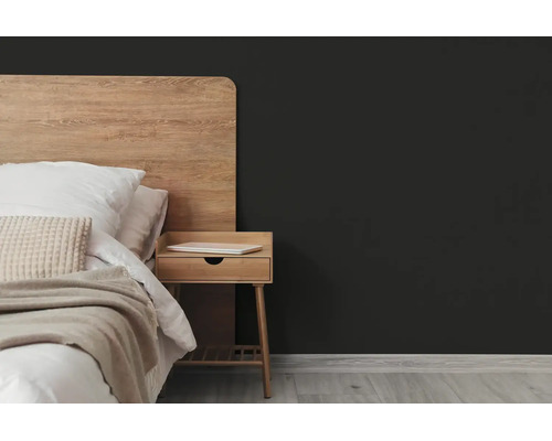 Donkergrijze muur in een moderne slaapkamer met houten bed, nachtkastje en lichte houten vloer.