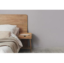 Moderne slaapkamer met een bed met houten hoofdbord, een bijpassend nachtkastje en een lichtgrijze muur.