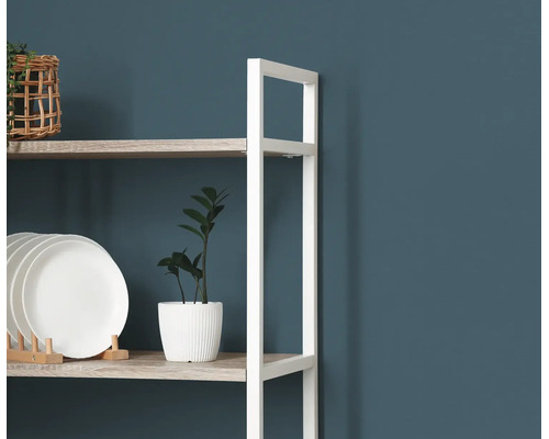 Moderne open stellingkast met wit metalen frame en houten planken, gedecoreerd met borden, een kamerplant en een mand.