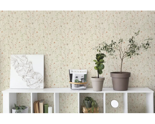 Vliesbehang met floraal patroon van delicate veldbloemen achter een witte kast met kamerplanten en decoratie.
