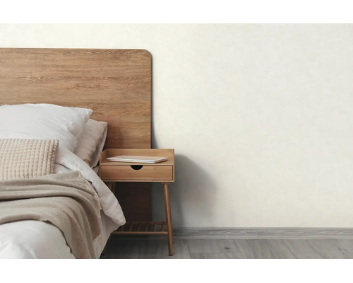 Lichte slaapkamer met houten bed, bijpassend nachtkastje, een lichte muur en vloer met houtlook.