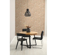 Lichte woonkamer met behang in steenlook, ronde houten tafel, zwarte stoelen en een hanglamp.