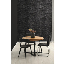 Behang in steenlook met donker baksteenpatroon in een modern ingerichte eetkamer met houten tafel en zwarte stoelen.