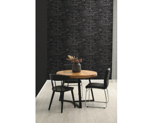 Behang in steenlook met donker baksteenpatroon in een modern ingerichte eetkamer met houten tafel en zwarte stoelen.
