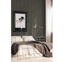 Moderne slaapkamer met donkergrijs behang met verticale strepen, beddengoed met ruitpatroon en een grijze bureaulamp op een bijzettafel.