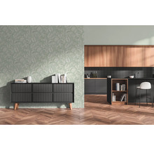 Vliesbehang met palmbladmotief in een moderne woonkamer met een zwart dressoir, open keuken en visgraatparket.