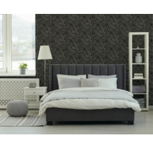 Moderne slaapkamer met donkergrijs gestoffeerd bed, wit nachtkastje en stellingkast voor behang met tropisch bladmotief.