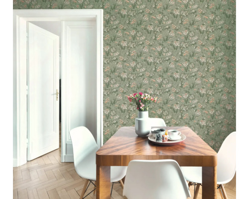 Vliesbehang met fijn bloemenpatroon in een lichte eetkamer met houten tafel en witte stoelen naast een open witte deur.