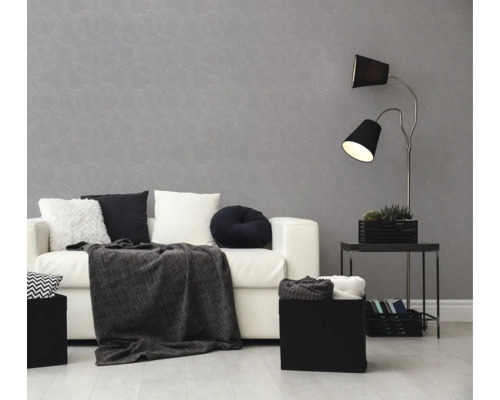 Vliesbehang met cirkelpatroon in woonkamer met witte bank, zwarte vloerlamp en sierkussens. Moderne sfeer in grijs en wit.