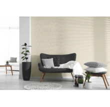 Behang met cirkelpatroon in een lichte, moderne woonkamer met donkere bank en planten.