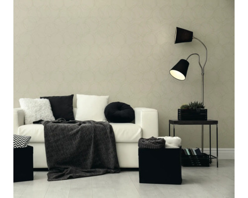 Moderne woonkamer met behang met cirkelpatroon, witte bank, zwart-witte kussens, een donkere deken en een vloerlamp met twee lampenkappen.