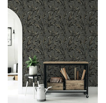 Behang met bladpatroon in een lichte kamer met een ronde boog, een houten consoletafel, een kamerplant en een gieter.